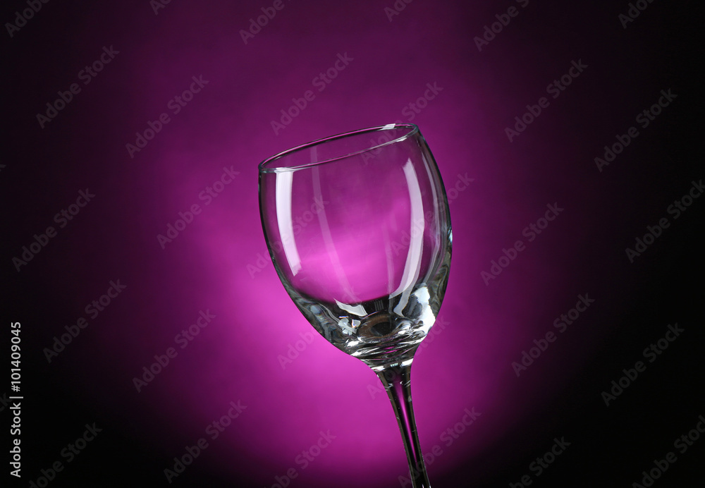 Empty wineglass on dark purple background
