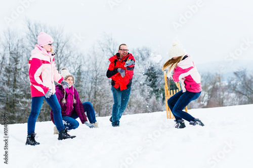 Familie mit Kindern hat Schneeballschlacht im Winter