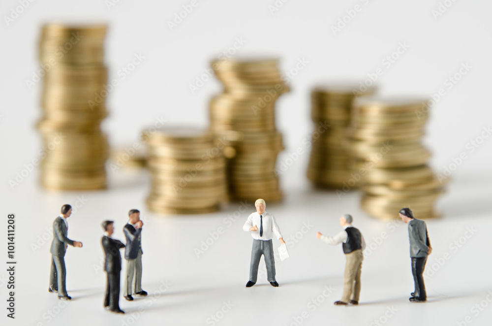 miniature businessman team training with gold coins stack backgr miniature businessman team training with gold coins stack backgr