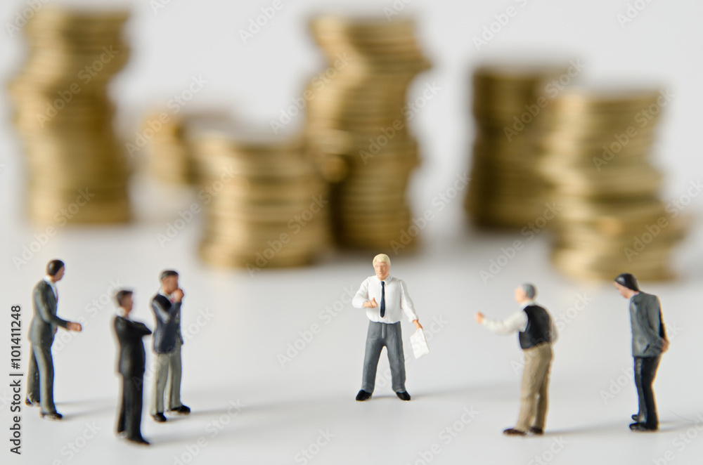 miniature businessman team training with gold coins stack backgr miniature businessman team training with gold coins stack backgr