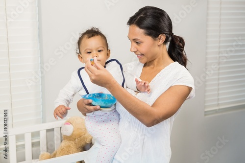 Smiling brunette feeding baby photo