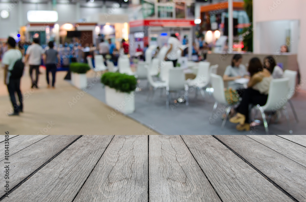 white wood table with blurred event background