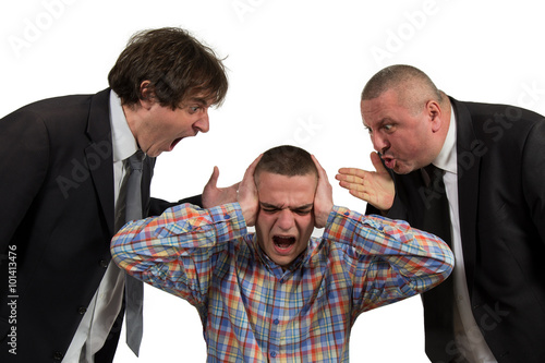 Young man being yelled at by two senior male manager on white