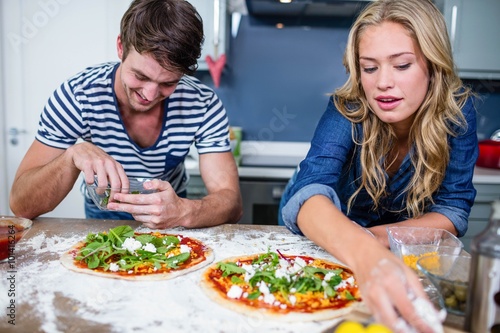 Smiling couple preparing pizza