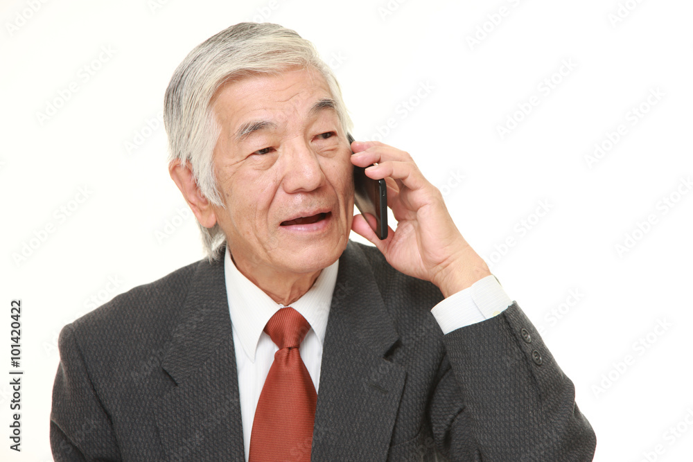 senior businessman talks with a smart phone senior businessman talks with a smart phone
