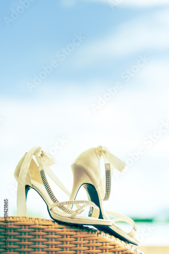 Close-up of bridal shoes with crystal necklace. Shallow depth of field. Cross process. © hkt83000