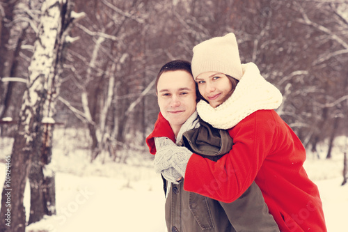 Embracing couple looking at camera with smiles in winter park