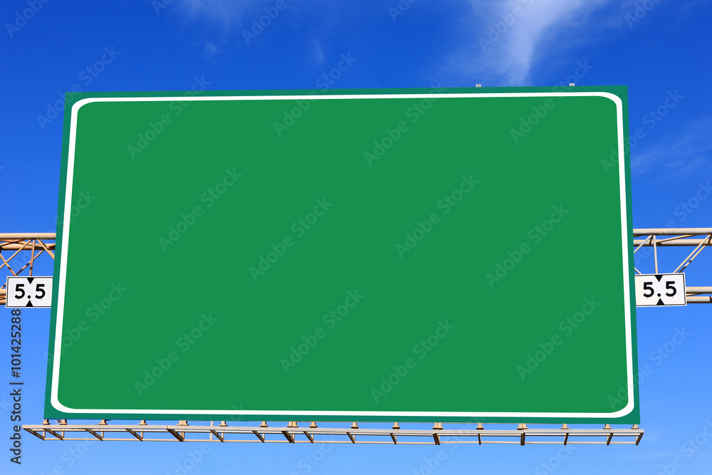 Green highway sign with blue sky in the background Green highway sign with blue sky in the background