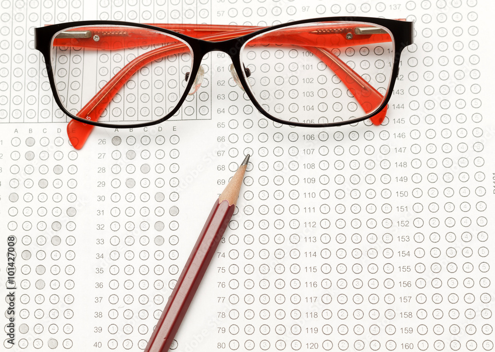 glasses and pencil on Standardized test form with answers bubbled in and a pencil, focus on anser sheet glasses and pencil on Standardized test form with answers bubbled in and a pencil, focus on anser sheet