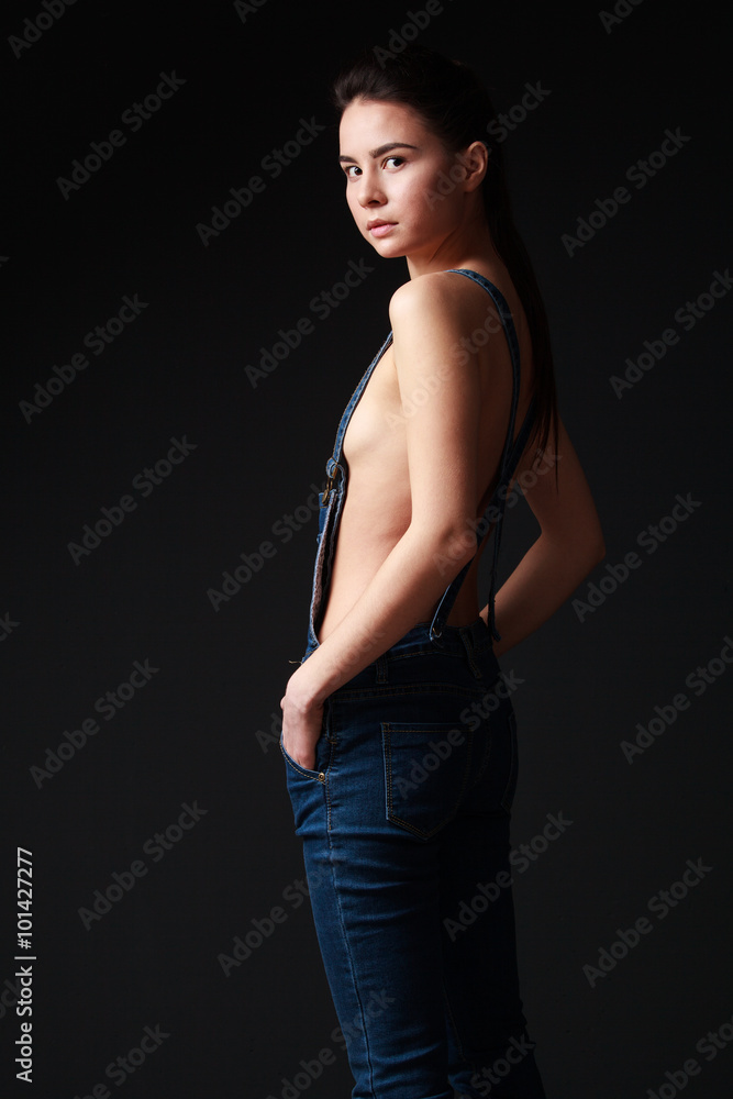 Young brunette woman in jeans overalls with naked torso Stock Photo | Adobe  Stock