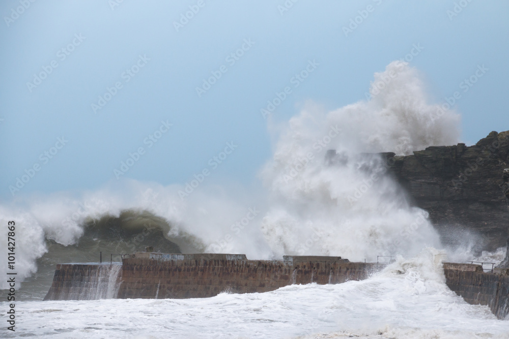 Storm waves hit cliff and harbour at Portreath, Cornwall, UK