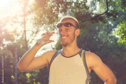Jogger drinking water after running.