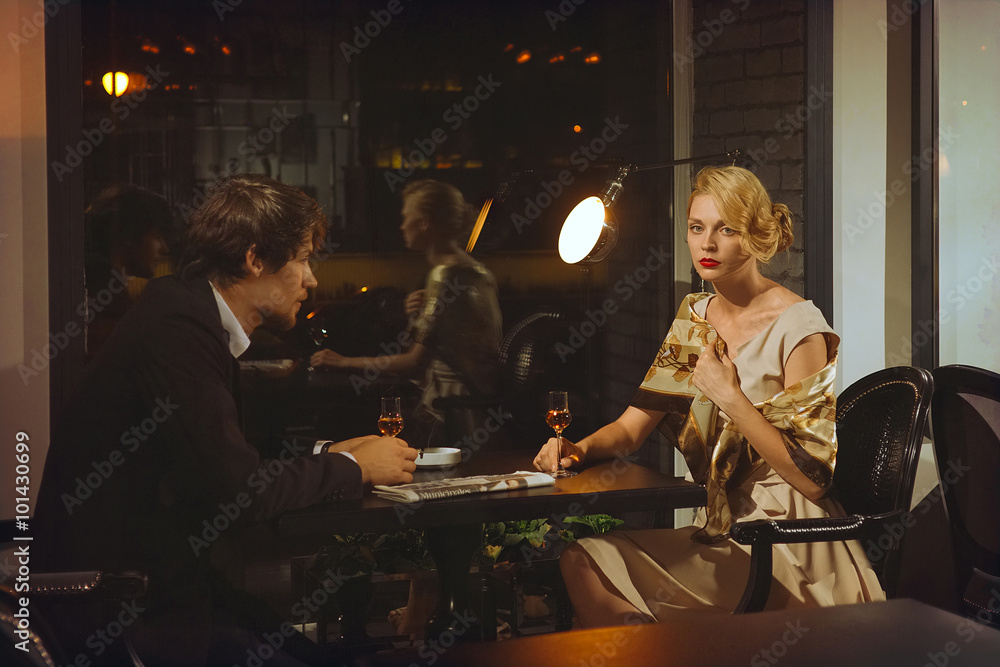 attractive lady in dress and man in suit in cafe.
