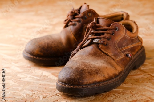 Pair of old worn shoes on wooden boad
