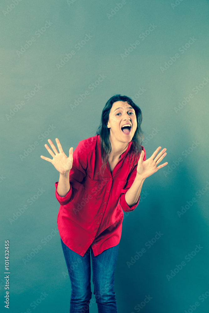 success concept - extrovert 30s woman expressing herself with dynamic hand gesture for joy or fun,studio shot, blue effects..