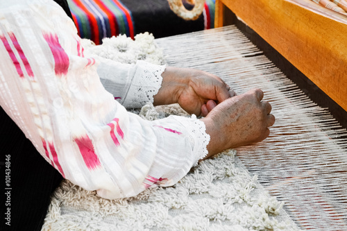 Elderly woman in lace shirt doing weaving photo