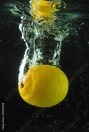 Lemon in the bubbles on a dark background