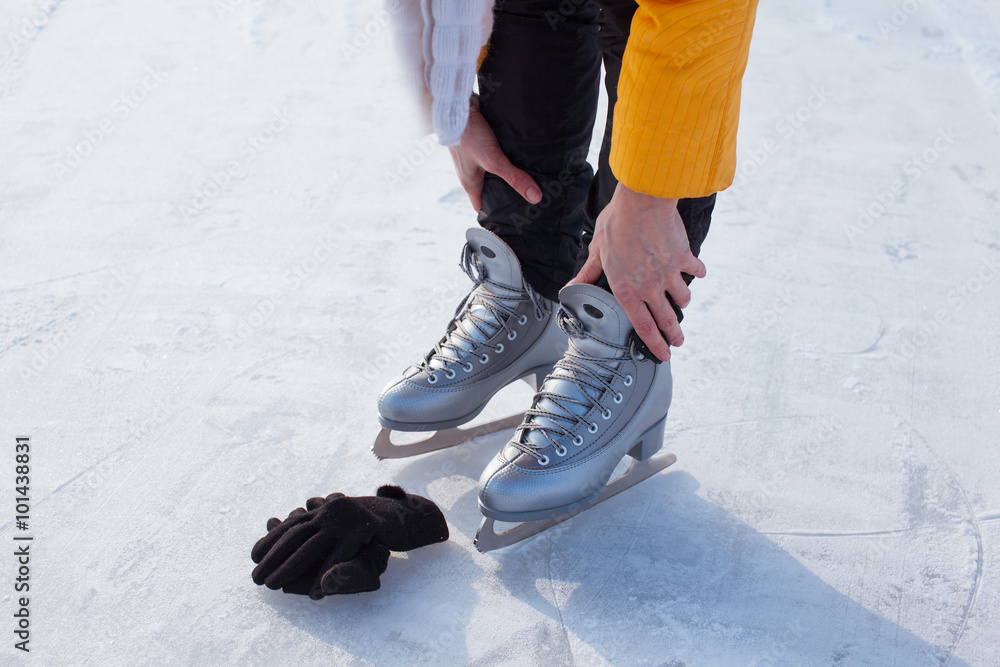 Young woman ice skating outdoors on a pond on a freezing winter day - detail of the legs. Young woman ice skating outdoors on a pond on a freezing winter day - detail of the legs.