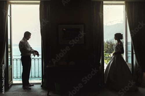 Beautiful sexy bride and handsome groom separate on balcony at r