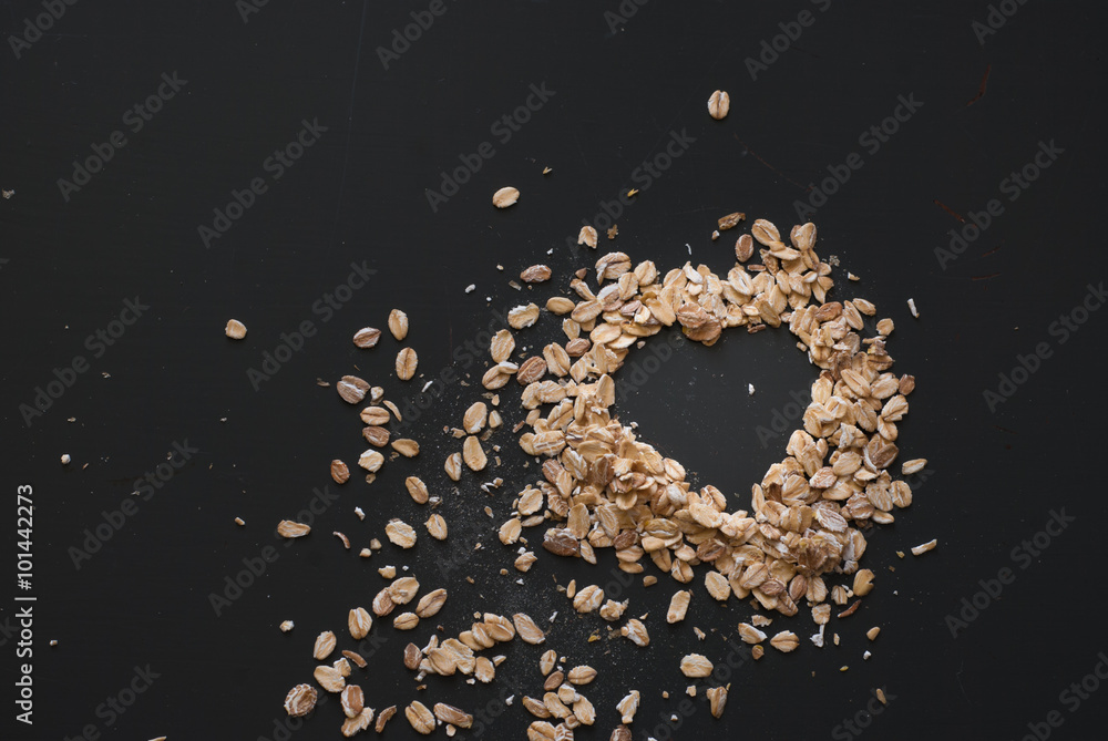 oat flakes heart on dark wooden table oat flakes heart on dark wooden table