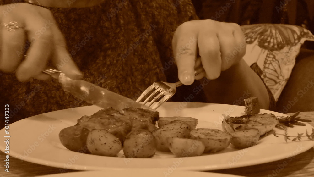Woman is having dinner, old style sepia view with grain Woman is having dinner, old style sepia view with grain