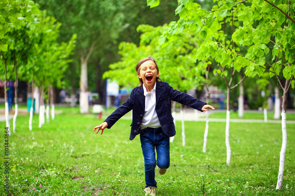 Happy little brunette boy runs in a summer park Happy little brunette boy runs in a summer park