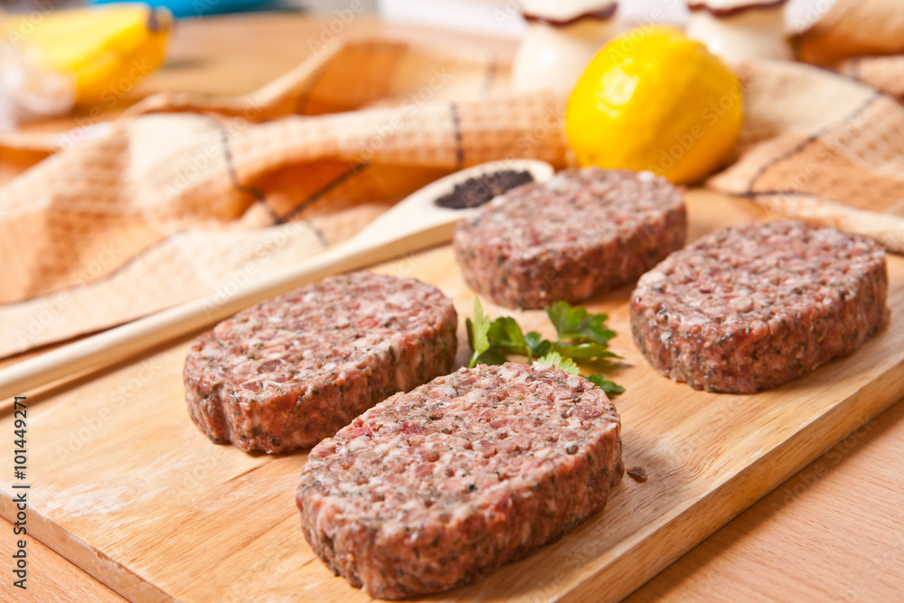 raw patties with spices on the kitchen table