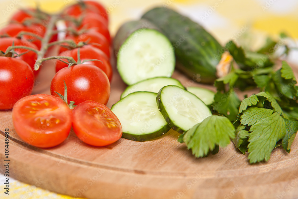 cherry tomatoes, cucumbers and parsley close-up on the board cherry tomatoes, cucumbers and parsley close-up on the board