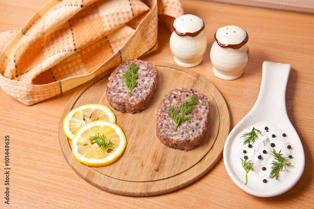 raw cutlets with lemon slices on a cutting board raw cutlets with lemon slices on a cutting board