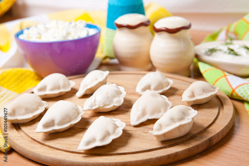 raw dumplings on a cutting board with cheese