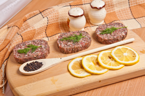 raw cutlets with lemon slices on a cutting board