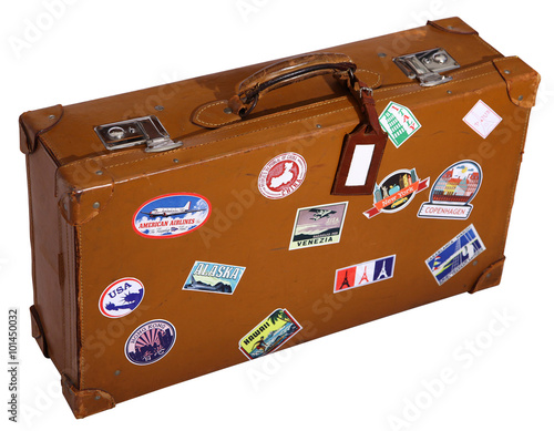 Old brown suitcase with name tag and travel sticks