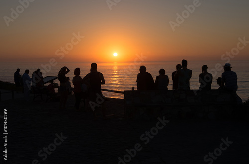 People watching sunset over the ocean