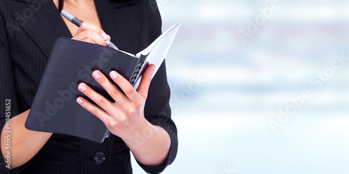 Woman writing in a diary book.