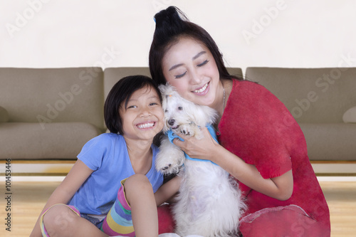 Playful mother and her daughter with dog