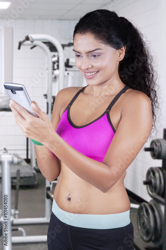 Woman holds cellphone at gym