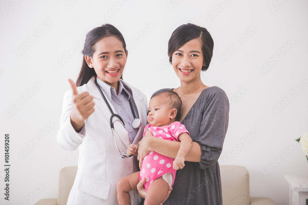 Asian young mother consulting with a pediatrician, holding her b Asian young mother consulting with a pediatrician, holding her b