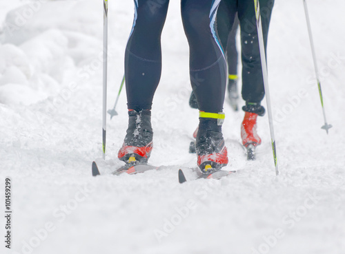 Close up of colorful skies, feet and legs of two cross country s