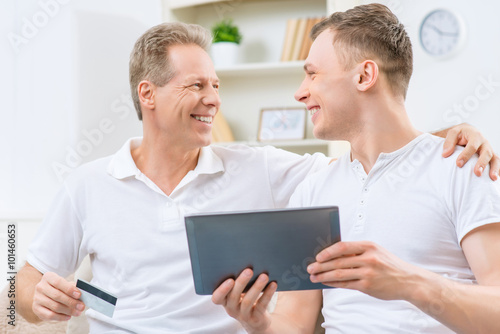 Father and adult son holding tablet  © zinkevych