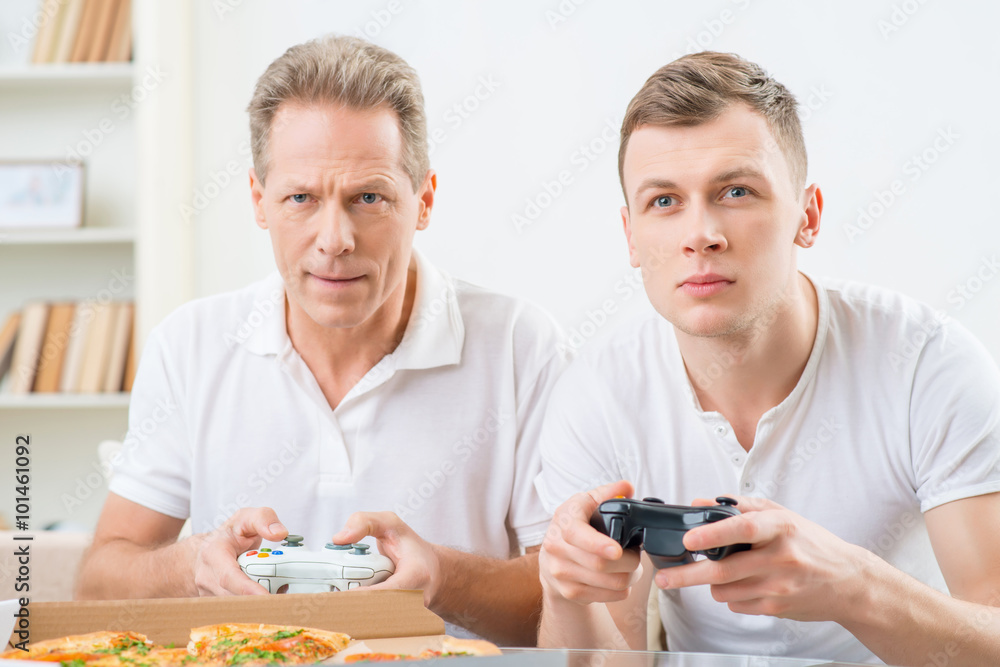 Father and adult son playing video games Father and adult son playing video games