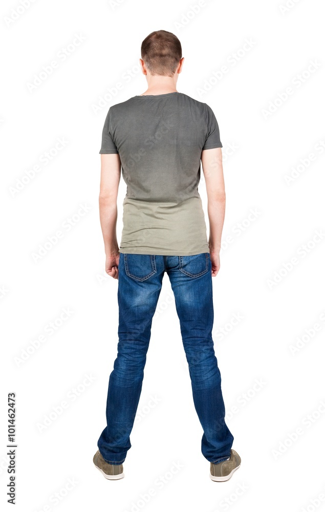 Back view of young man in t-shirt and jeans looking. Back view of young man in t-shirt and jeans looking.