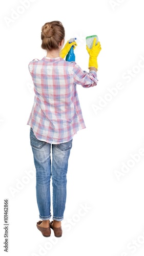 Back view of a housewife in gloves with sponge and detergent