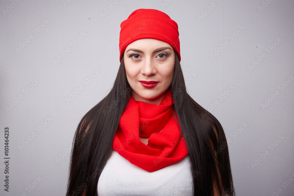 Brunette in red scarf and hat smiling in the studio Brunette in red scarf and hat smiling in the studio