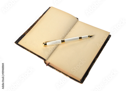 Fountain pen lying on old open book page, shallow DOF