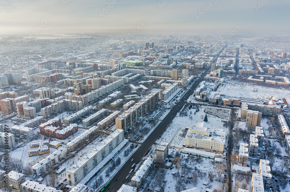 Tyumen, Russia - January 23, 2016: Aerial view on city quarters, city drama theater and square with big fir-tree and ice slopes