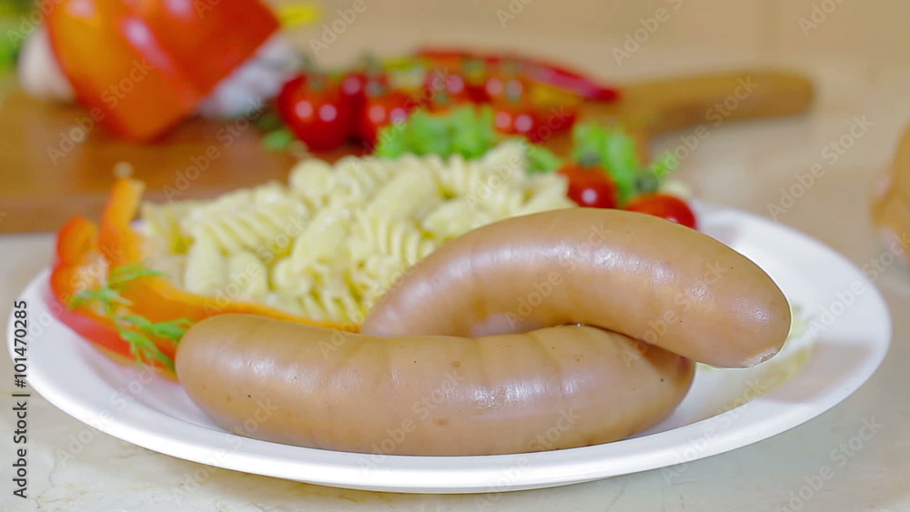 Sausages served on plate with pasta and vegetables Sausages served on plate with pasta and vegetables