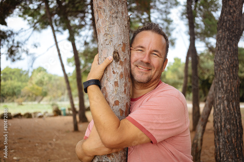 Adult man hugging the tree