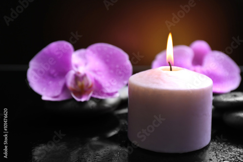 Composition of orchid  pebbles and candle on dark background