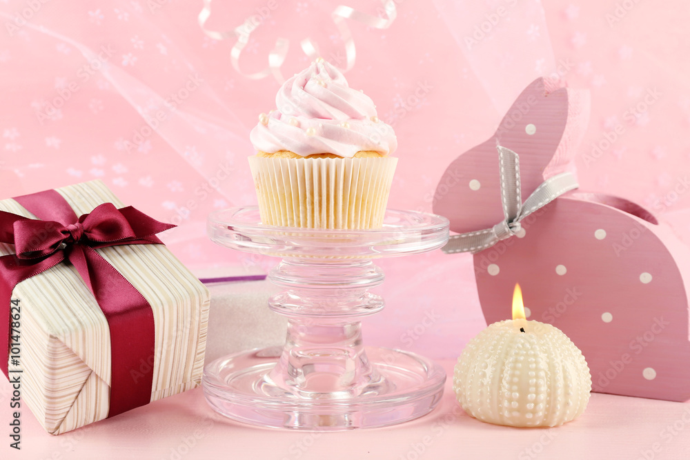 Tasty cupcake with gifts and decorations on pink background Tasty cupcake with gifts and decorations on pink background