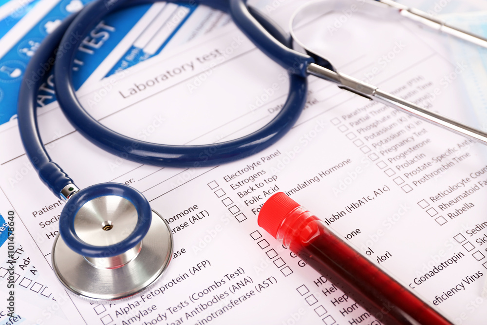 Blood in test tubes, stethoscope and investigation form on the table, close-up Blood in test tubes, stethoscope and investigation form on the table, close-up
